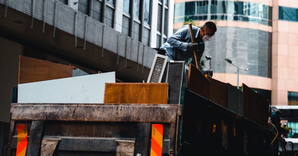 A man wearing a mask manages construction debris in a city environment from a large truck.